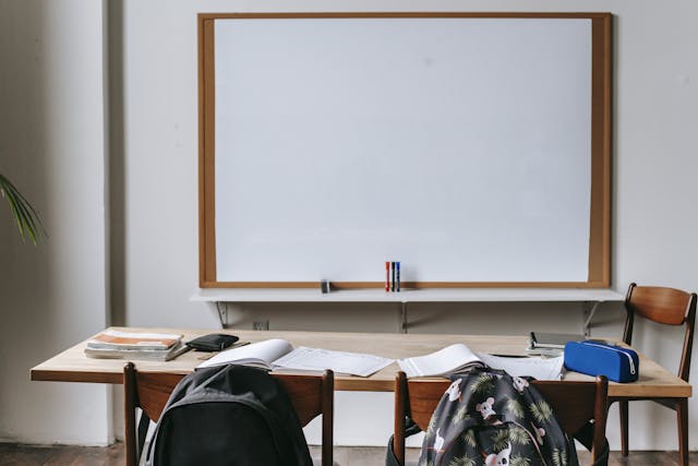 Classroom with whiteboard and desk with stationery